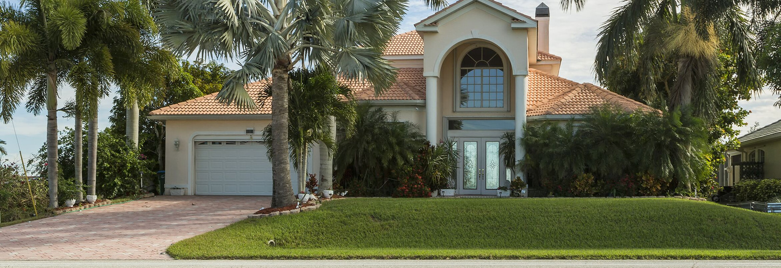 Photo of home for sale with palm trees in front of it